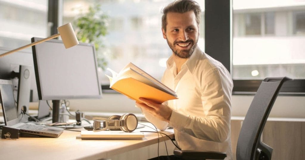 Confident man smiling at work after confidence hypnotherapy