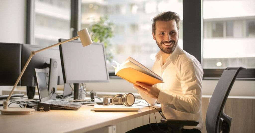 Confident man smiling at work after confidence hypnotherapy