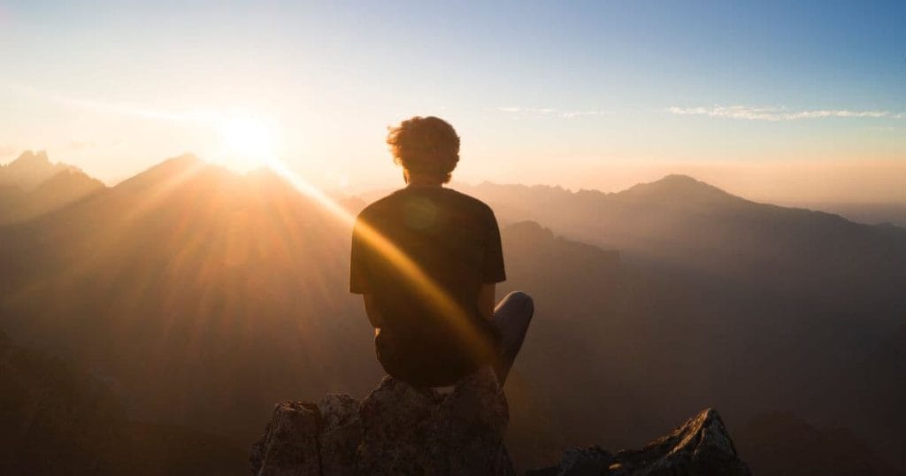 Man reflecting at sunrise, representing calm and clarity after RTT® Hypnotherapy