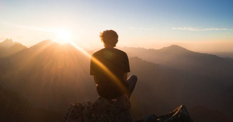 Man reflecting at sunrise, representing calm and clarity after RTT® Hypnotherapy