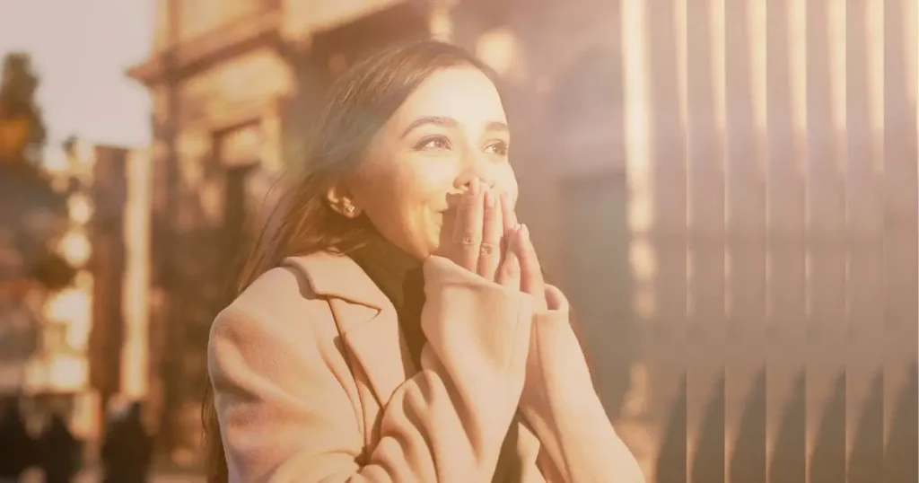 Woman smiling and covering mouth in surprise, symbolising increased confidence after RTT hypnotherapy