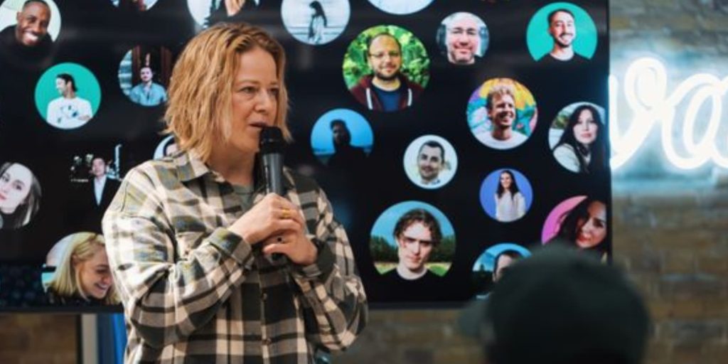 Woman speaking to a group with a mix of confidence and slight hesitation during a presentation.